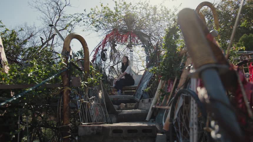 A girl sits up the steps in the garden