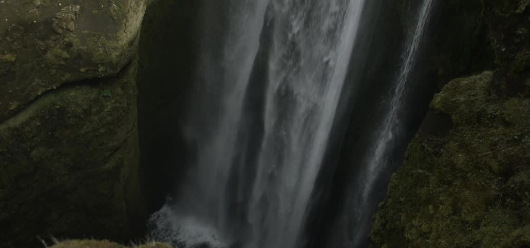 Water cascades down the side of a cliff