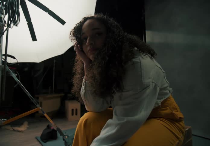 Woman sits on the set of a photography studio