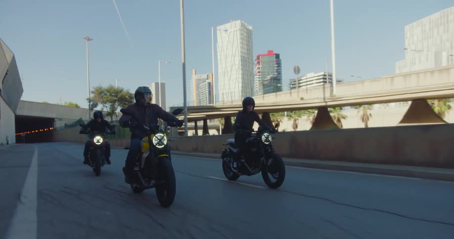 Three bikers riding their motorcycles on a city freeway