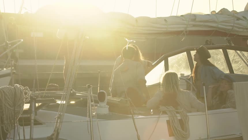 A group of women in a boat with a couple men as they laugh and smile