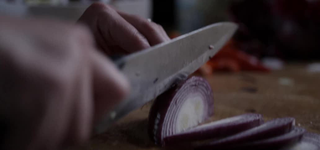 Person chopping an onion with a knife