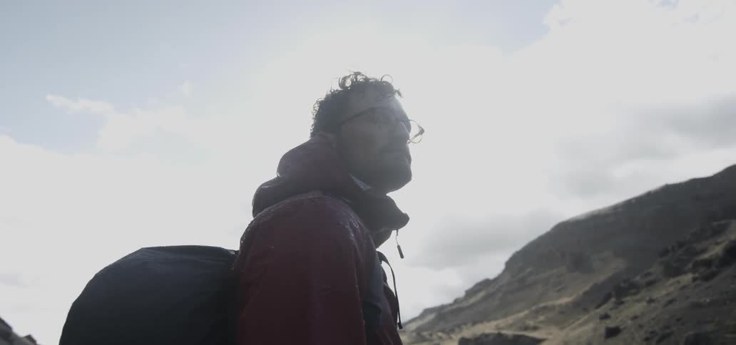 A man in glasses looks at his surroundings on a sunny day