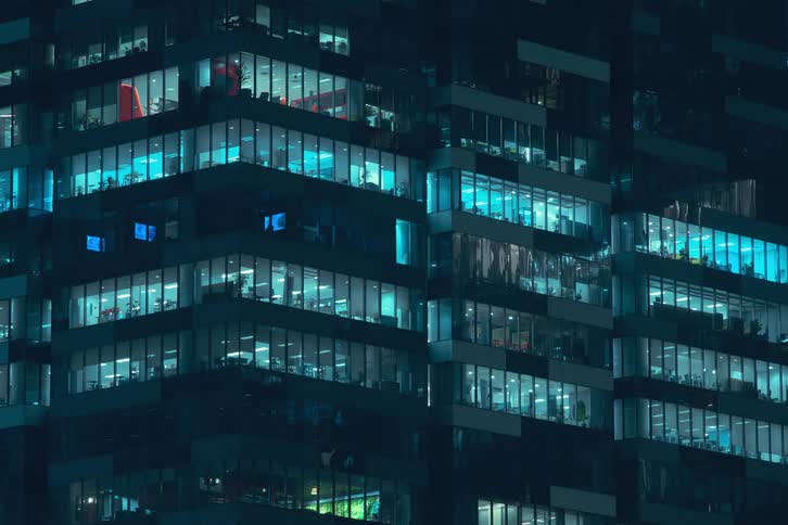 A time lapse of a high rise office building at night with lights in the windows flashing