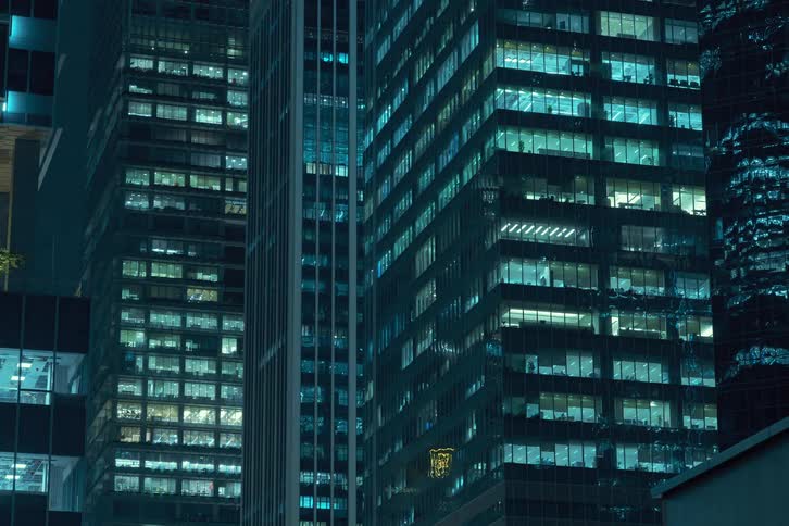 Building interior lights come on  in downtown skyscrapers at night