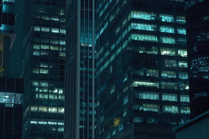 A time lapse of high rise office buildings at night with lights in the windows flashing rapidly