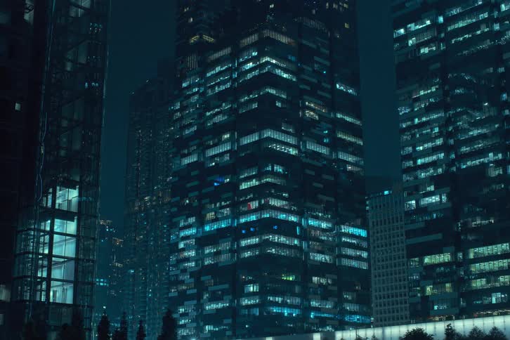 The lights of apartment buildings flicker as the night goes on