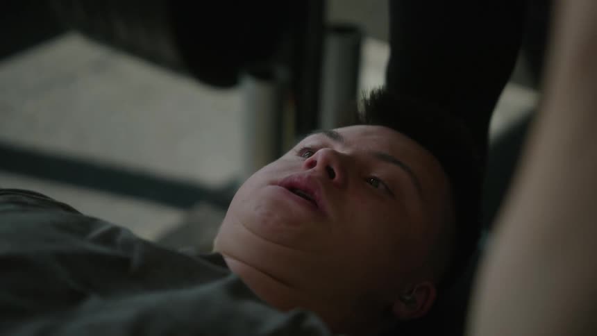 Close up of a teenage boy doing a bench press with a weight bar