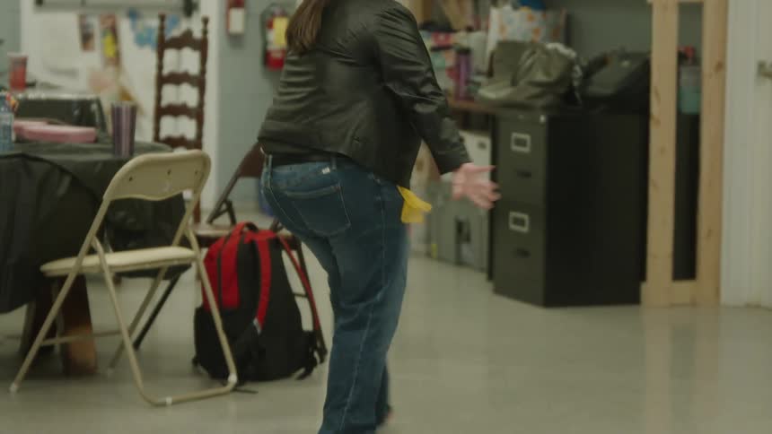 A teenage girl with Down syndrome dancing alone in a classroom