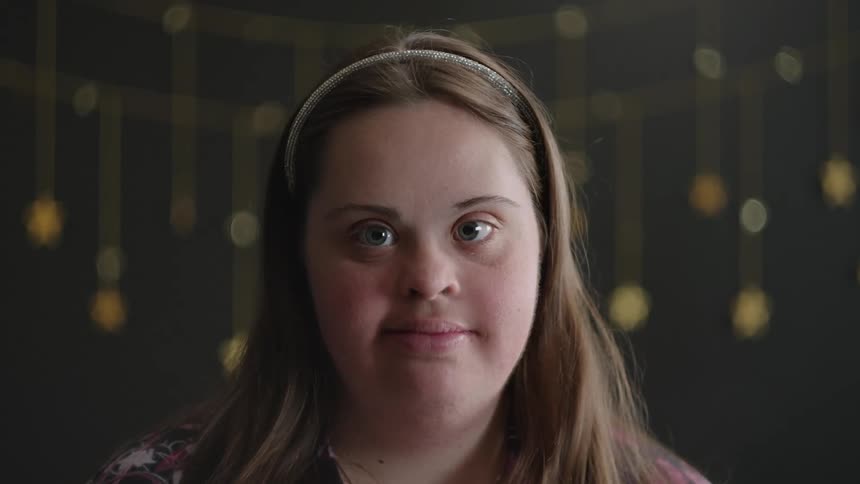 The face of a young blonde woman staring straight ahead