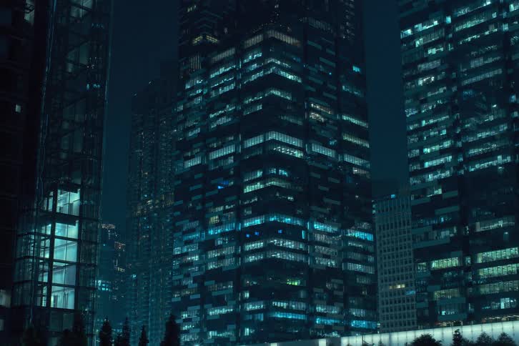 Some large buildings with several apartments with the lights blinking quickly during the night