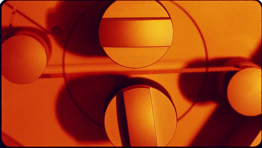 Close up of photography film moving through a machine as light flashes on the machine