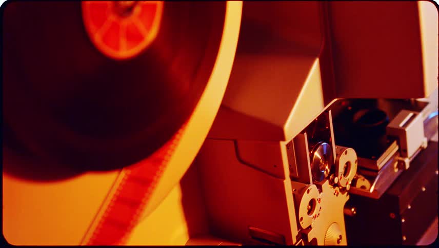 Film running through a rotating slide into a machine with flashing lights