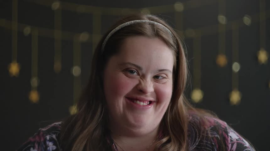 Close up of a young womans face with her expression going from serious to happy