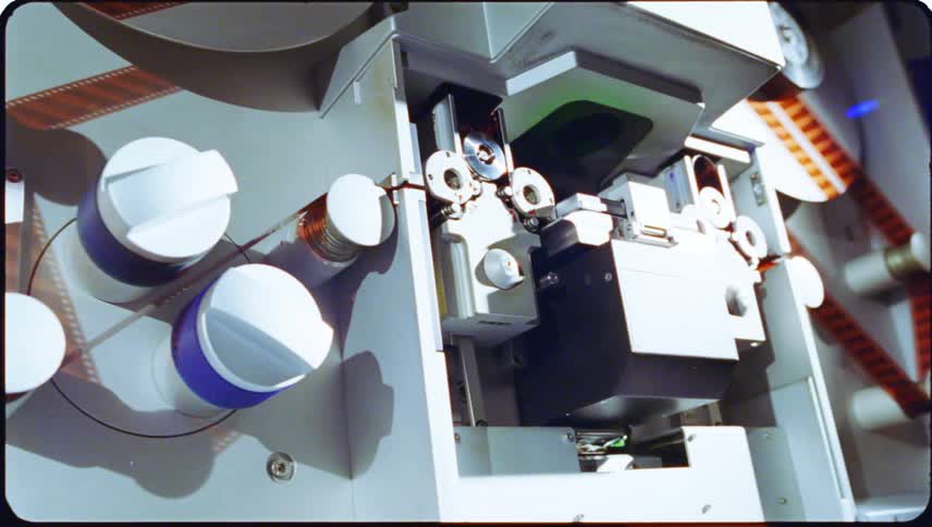 Closeup view of film threading equipment with cylindrical reels and components