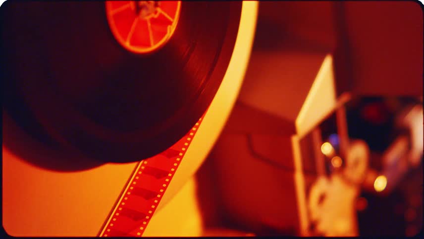 Film leaves the spool slowly while a light flashes in the background
