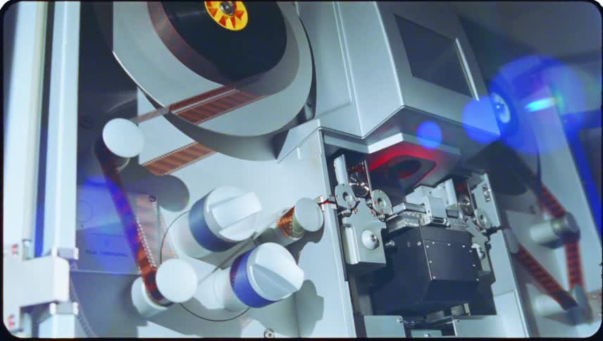 Closeup view of film threading equipment with cylindrical reels and components