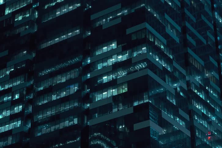 The lights in the apartments of a large building flicker at high speed