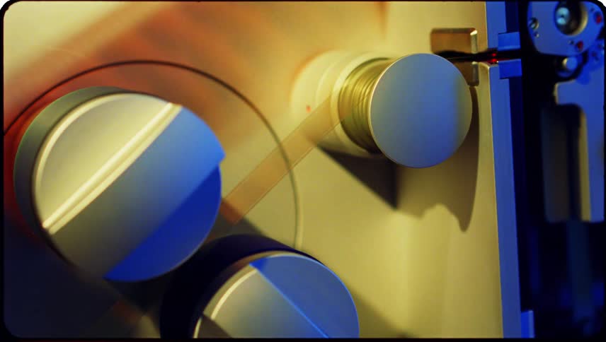 Closeup view of film threading equipment with cylindrical reels and components