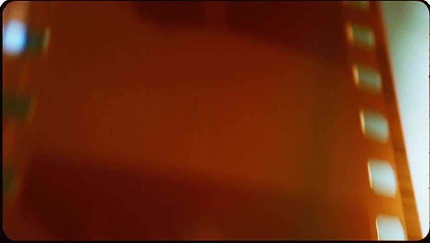 Close up of an orange film reel moving up a slide
