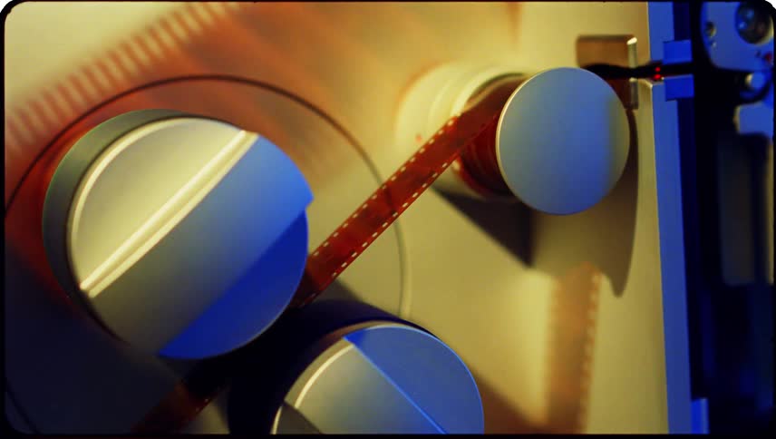 A machine pulling a roll of amber colored film