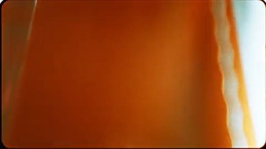 A close up of orange photo film with ridges cut out of the edges