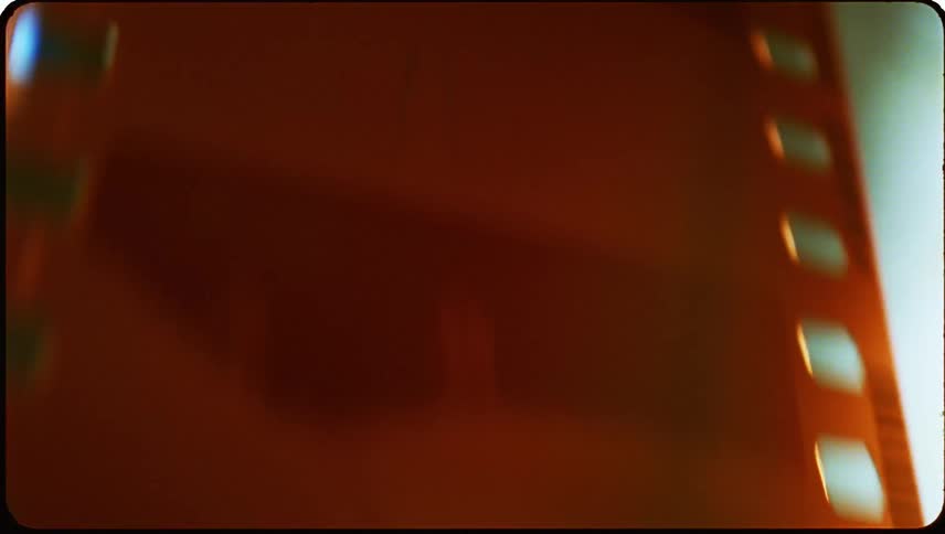 Closeup view of a section of a reddish brown film strip with transparent frames