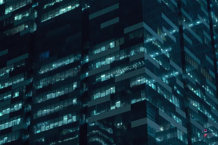 Time lapse of a large building in the city with lights on flickering on different levels