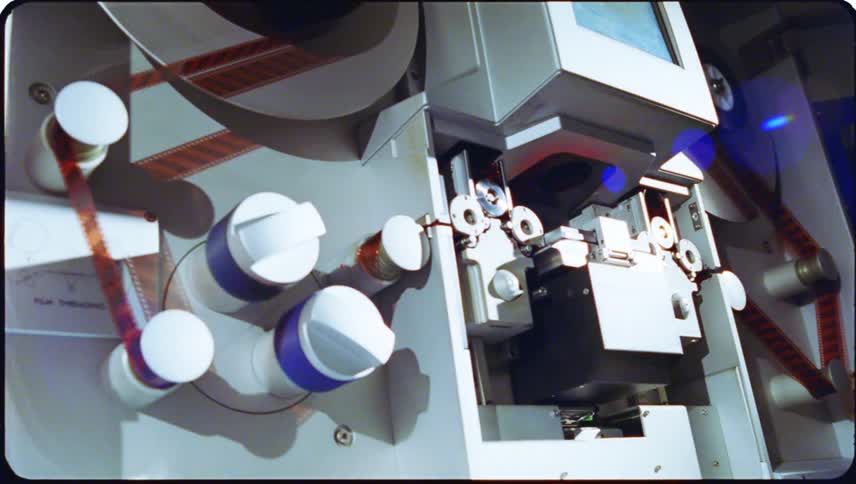 Closeup view of film threading equipment with cylindrical reels and components