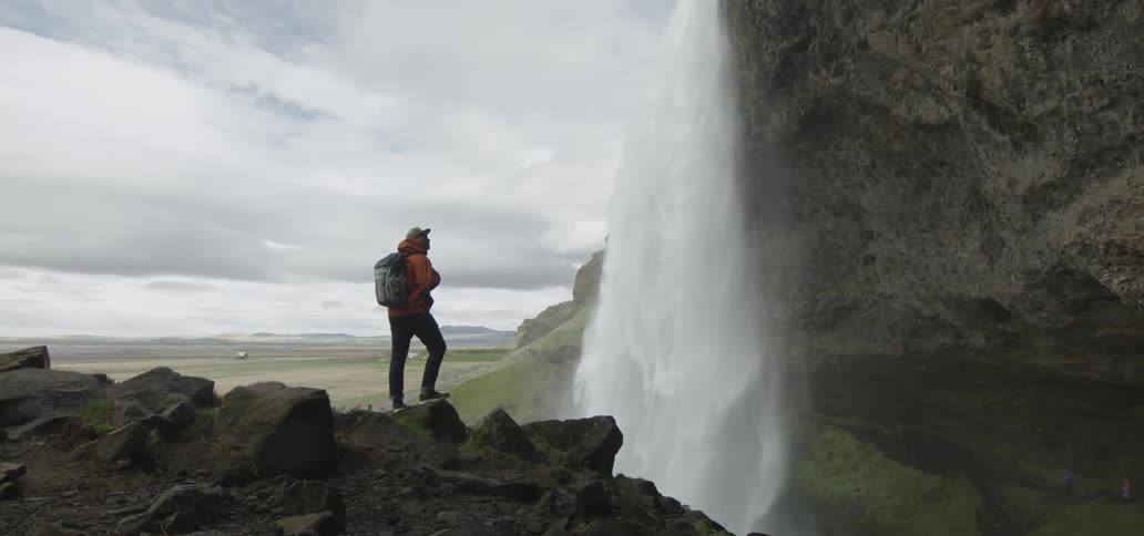 Man looking at a waterfall up close