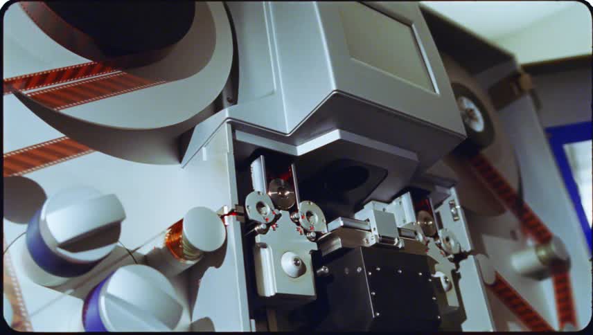 Closeup view of film threading equipment with cylindrical reels and components