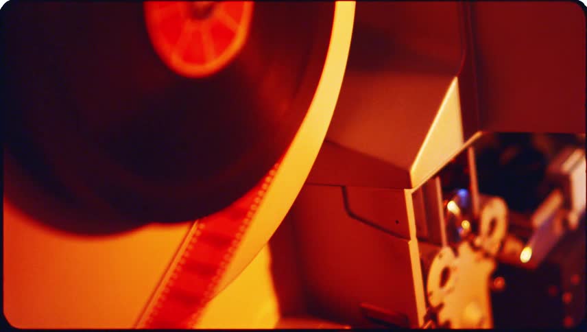 Photography film moving slowly through a machine with flashing lights