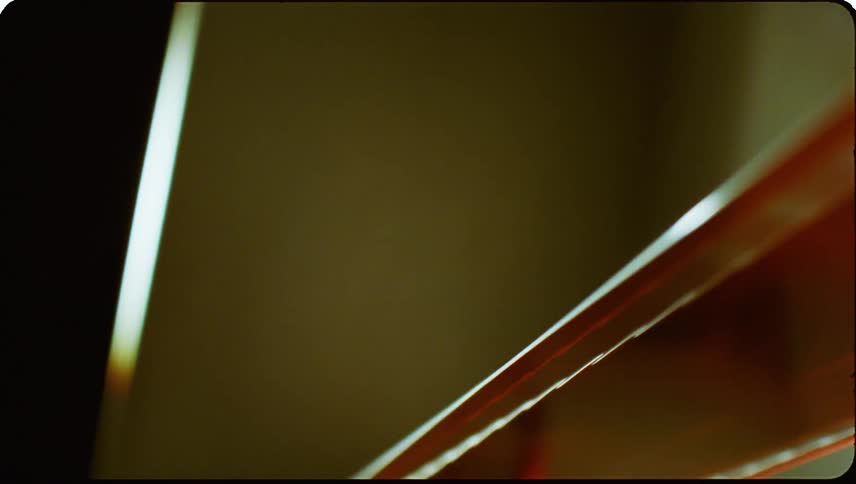 Closeup view of a section of a reddish brown film strip with transparent frames
