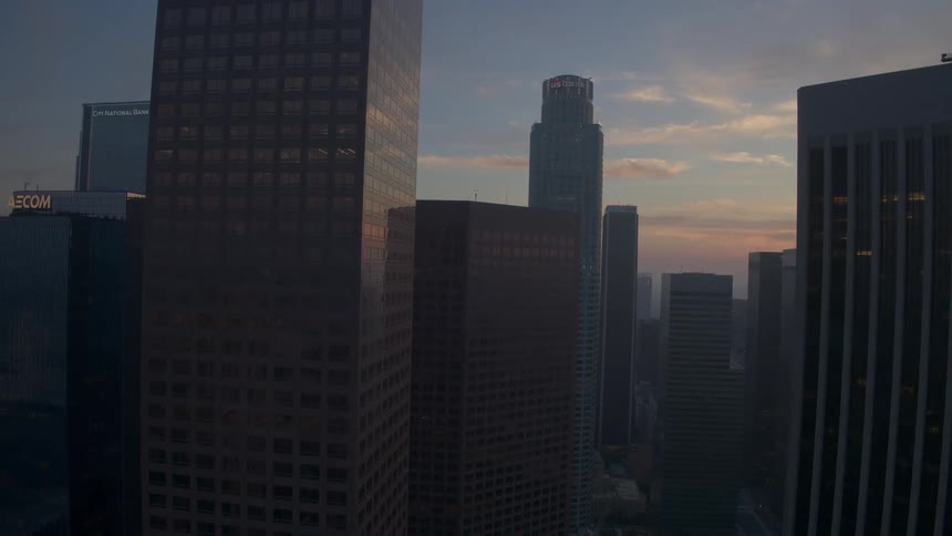 The camera rises up past the skyscrapers