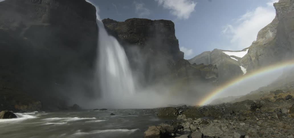 A rainbow caused by a tall waterfall