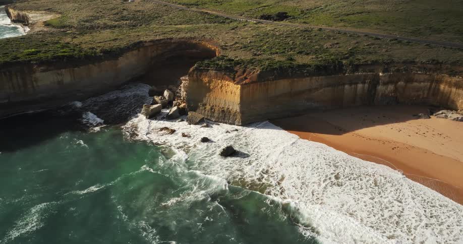 An aerial view of a rocky coastline with crashing waves