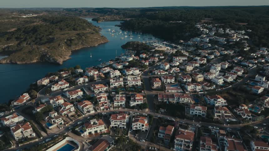 Aerial of a housing community bordering mountains and a lake