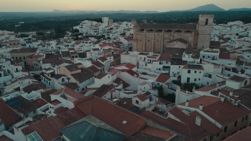 Aerial view of a medieval castle and a town at sunset