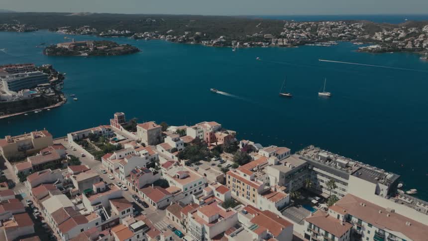 Boats move across water near a city