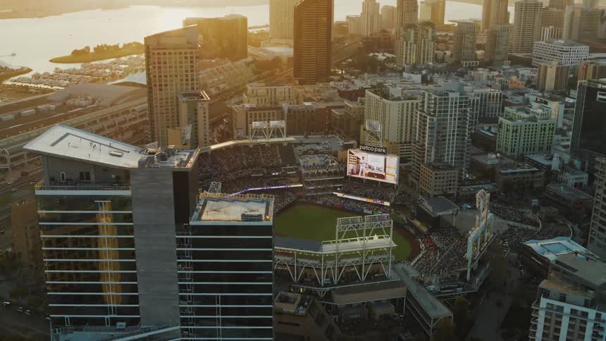 The camera reveals Petco Park sports arena at sunset filled with fans during a baseball game