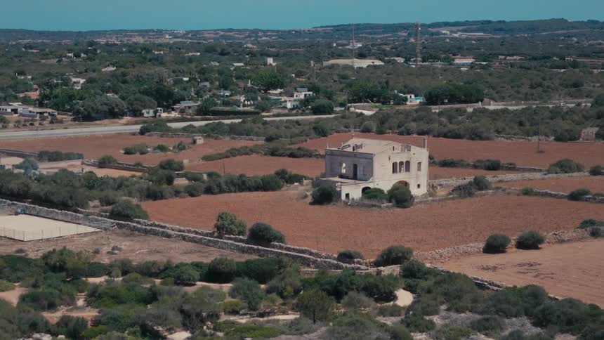 An old abandoned white monastery in the middle of a region with desert soil and little undergrowth