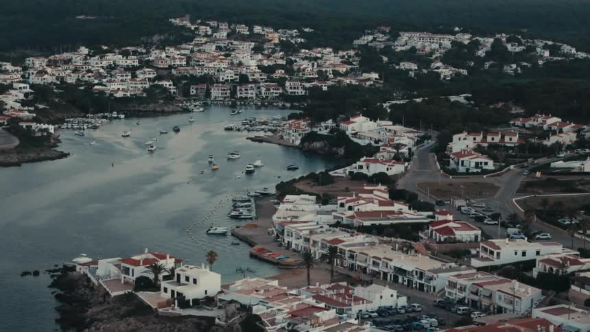 Boats fill a bay by a coastal town