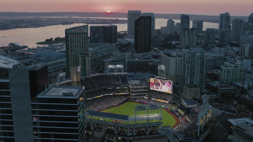 An aerial shot revealing Petco Park Stadium packed with fans and the downtown San Diego skyline at Sunset