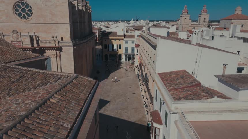 People walk by an ancient church in a dense city