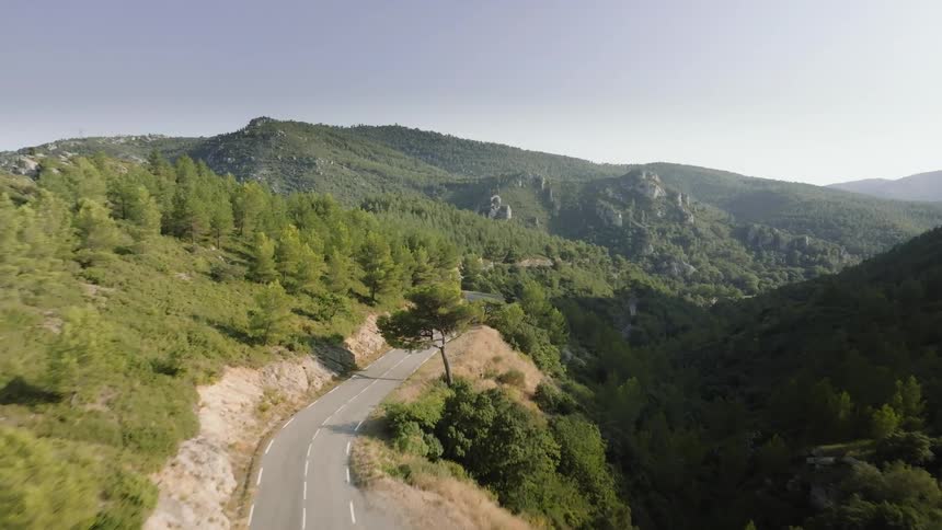 A winding road snakes through a lush green mountain valley
