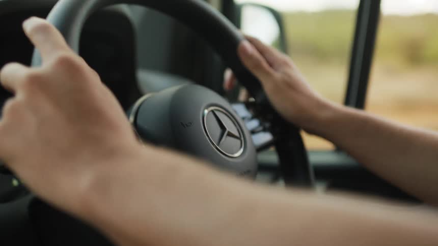 A clip of a persons hand holding the steering and driving