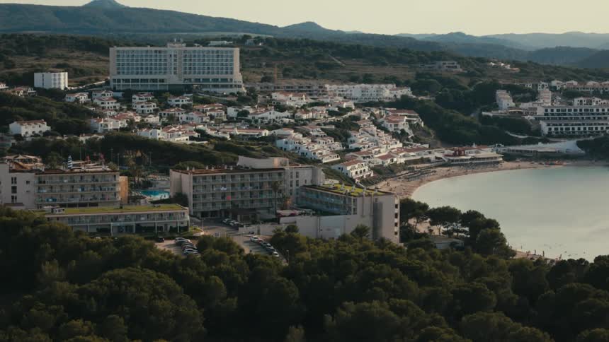 Hotels and residential buildings occupy the area between the woods the mountains and the beach in a coastal town