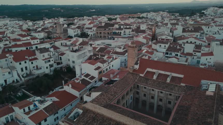 Red roofed buildings surround historic buildings in a small town