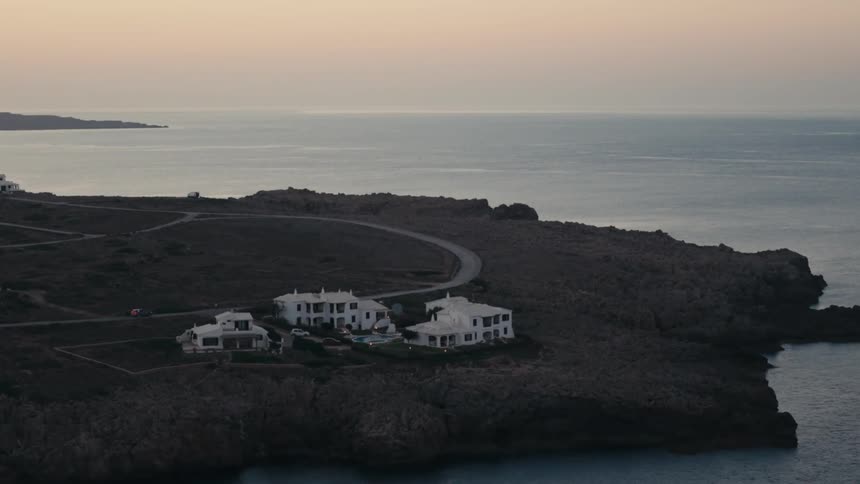 Vehicle drives down a highway curving along the peninsula past multiple mansions
