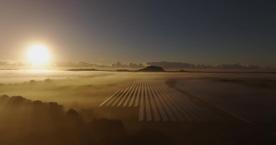 Heavy fog covers the solar panels at sunrise